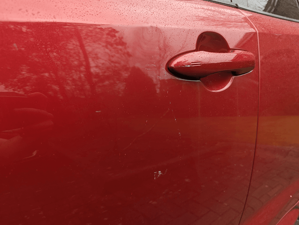 Red Corolla driver door scratches near handle evidence